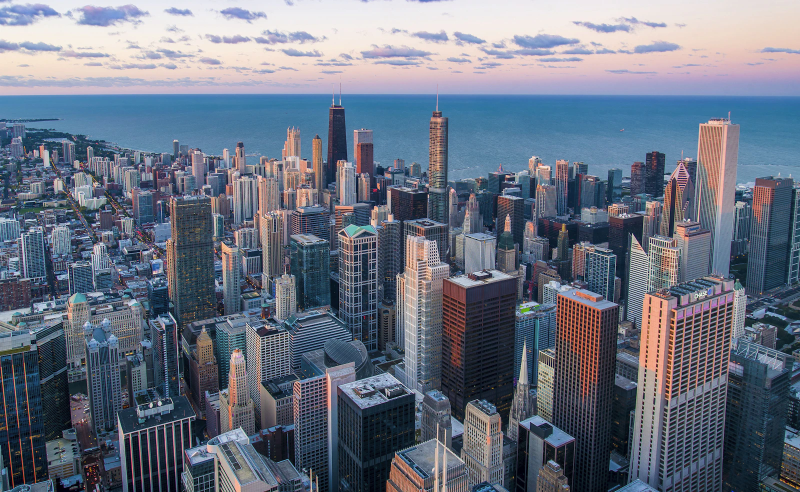 Vista aérea de um centro urbano com avenidas e edifícios ao anoitecer
